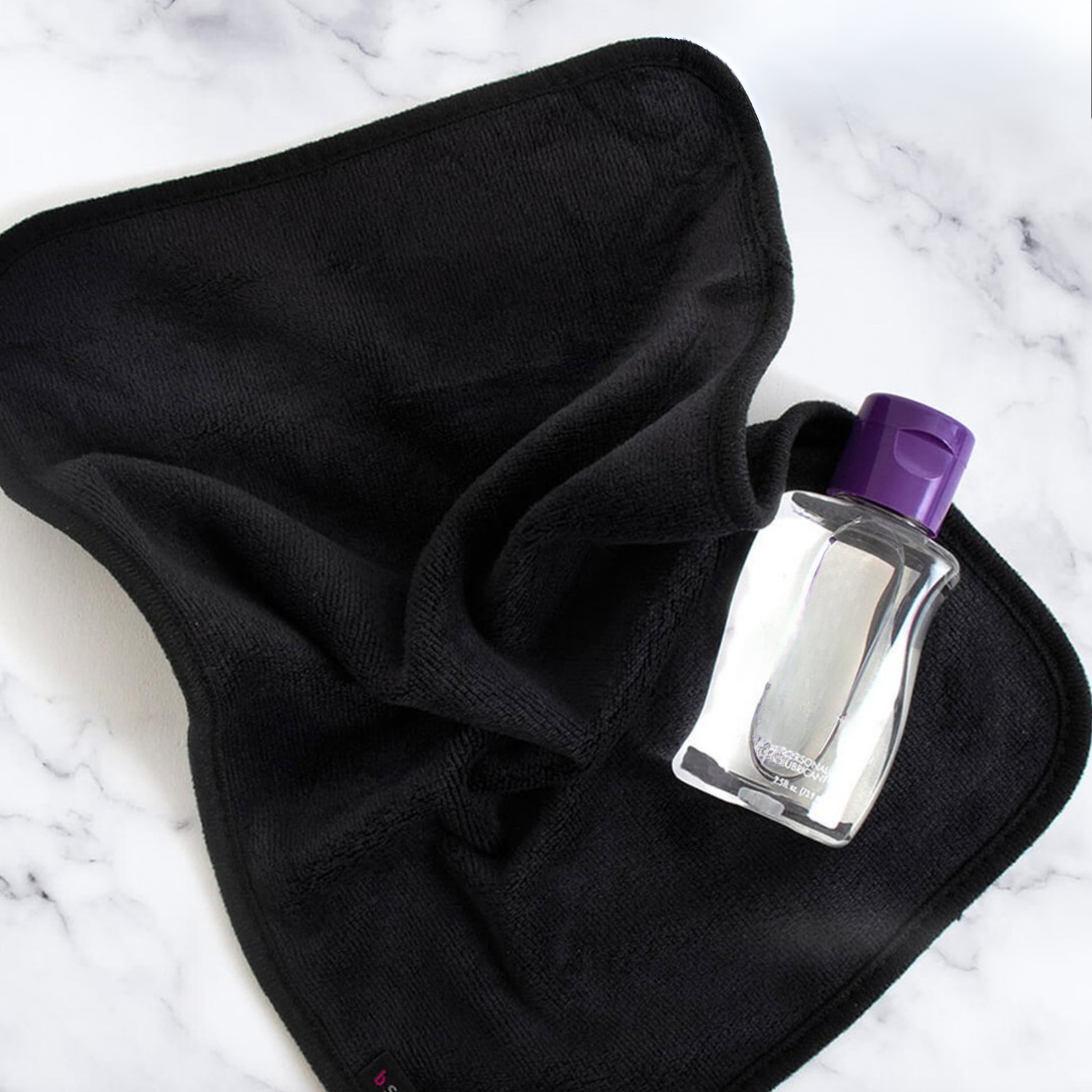 A soft black after-sex towel with a lubricant, ready for Post-Intimacy clean-up.